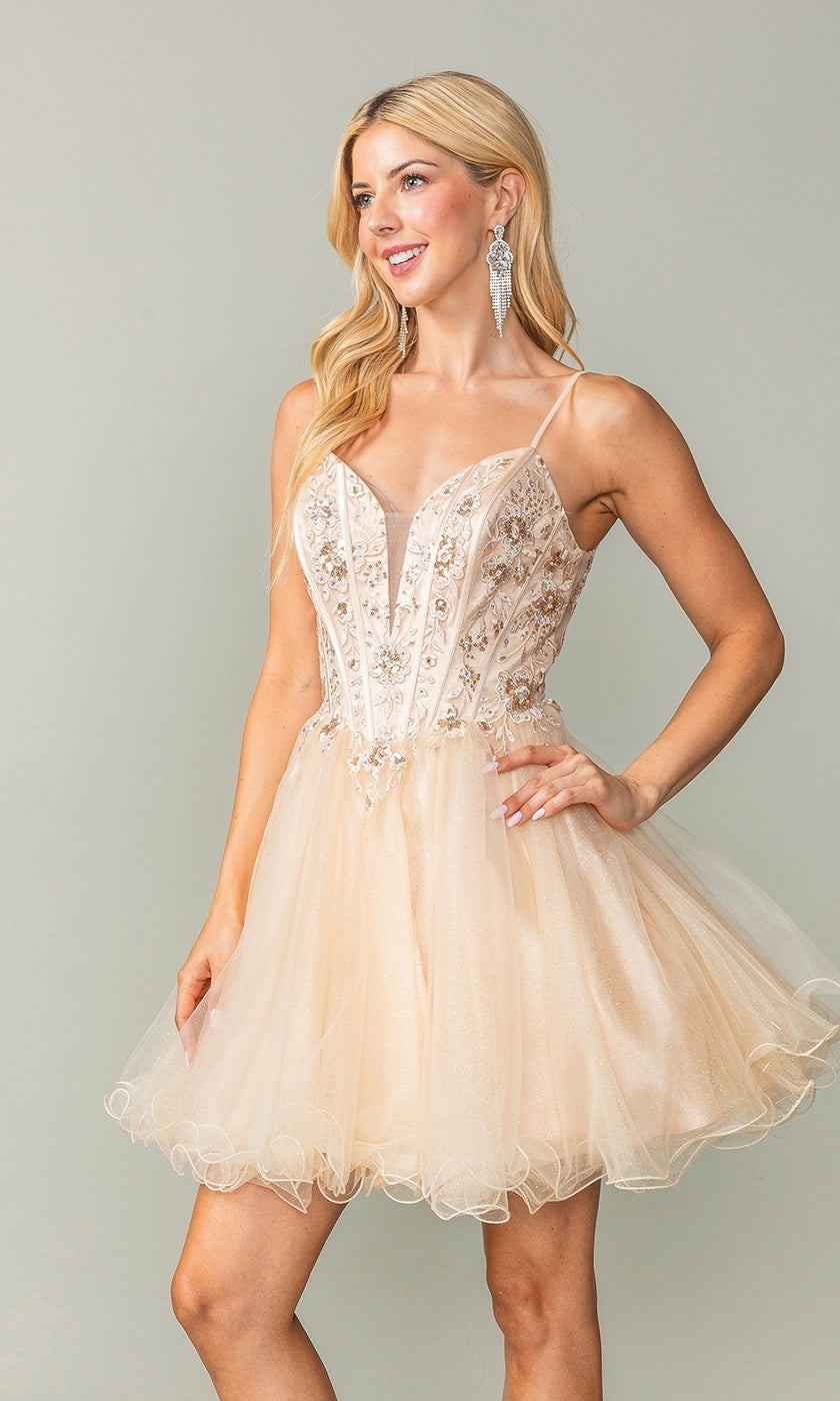A woman with long blonde hair wears the Sheer-Corset Short Babydoll Hoco Dress 3351, a light beige embellished tulle dress with spaghetti straps. She accessorizes with dangling earrings and smiles slightly to the side.